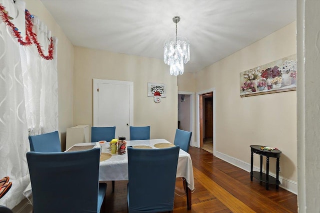 dining area with dark hardwood / wood-style flooring and a notable chandelier