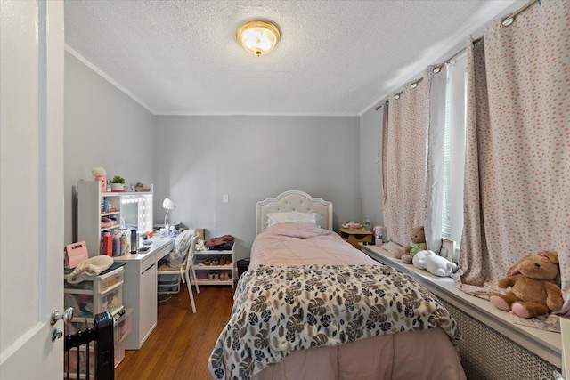 bedroom featuring ornamental molding, hardwood / wood-style floors, and a textured ceiling