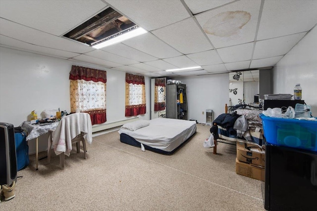 bedroom with a drop ceiling, carpet, and baseboard heating