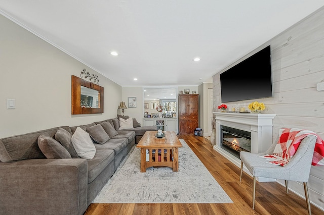 living room featuring wood-type flooring and ornamental molding