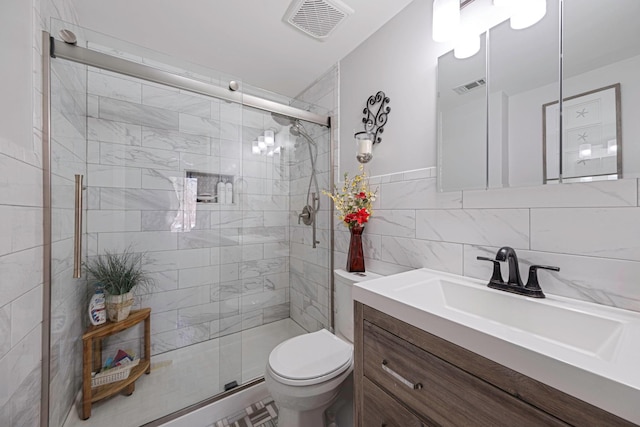 bathroom with vanity, tile walls, walk in shower, and toilet