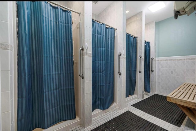 bathroom featuring tile patterned flooring, tile walls, and curtained shower