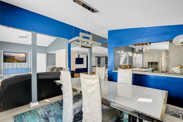 dining area featuring light wood-type flooring and lofted ceiling