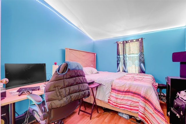 bedroom with wood-type flooring and vaulted ceiling