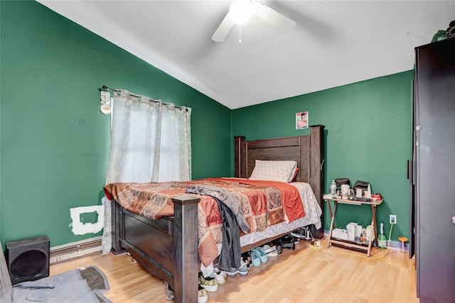 bedroom with wood-type flooring, baseboard heating, lofted ceiling, and ceiling fan