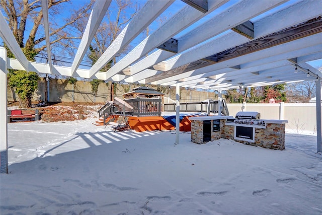 snowy yard featuring a gazebo, an outdoor kitchen, and a pergola