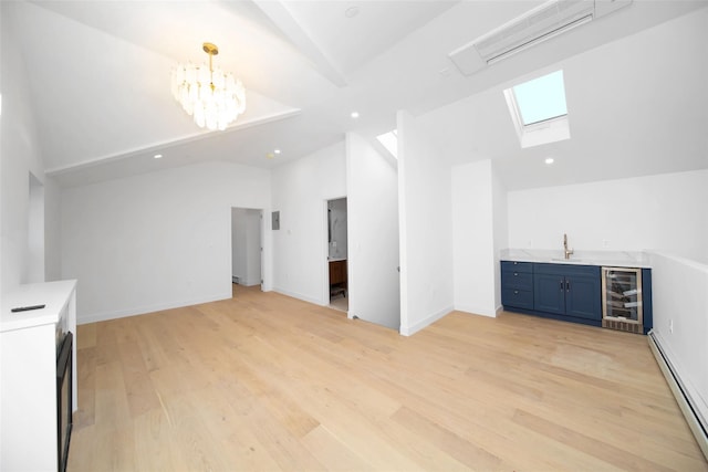 unfurnished living room with a baseboard radiator, wine cooler, light wood-type flooring, wet bar, and an inviting chandelier