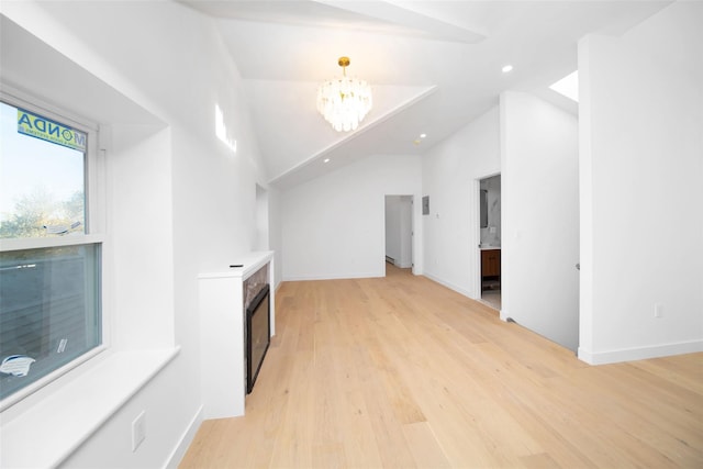 interior space with a chandelier, light hardwood / wood-style flooring, and vaulted ceiling