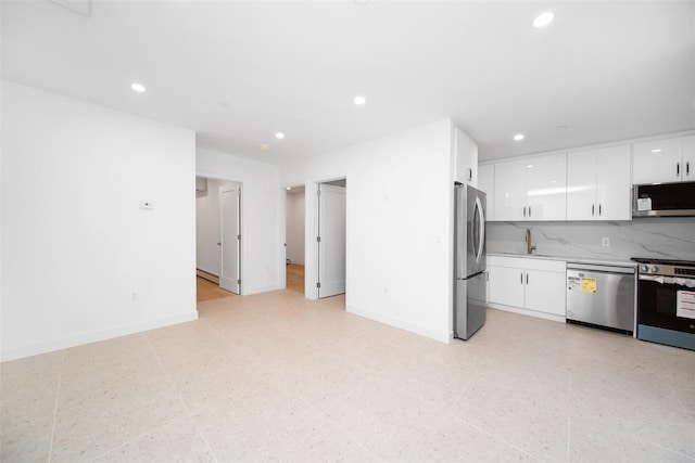 kitchen with sink, stainless steel appliances, white cabinetry, and backsplash