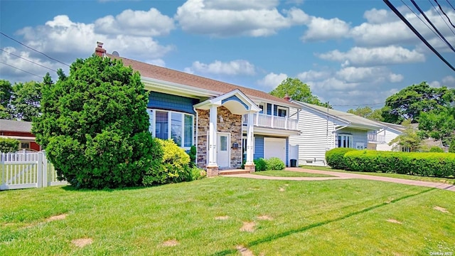 view of front of house with a balcony and a front yard