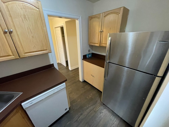 kitchen featuring dishwasher, light brown cabinets, dark hardwood / wood-style flooring, sink, and stainless steel refrigerator