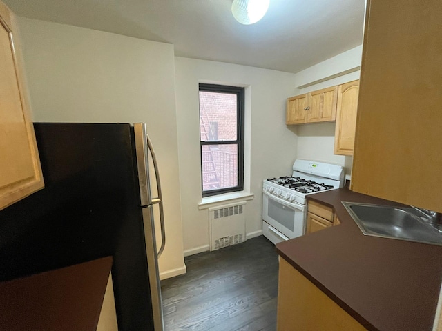 kitchen featuring light brown cabinets, radiator heating unit, dark hardwood / wood-style flooring, white range with gas stovetop, and sink