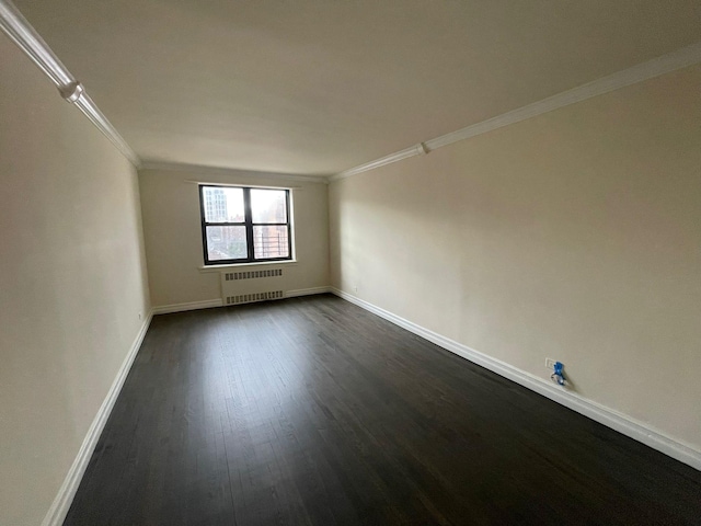 spare room with radiator heating unit, crown molding, and dark hardwood / wood-style flooring