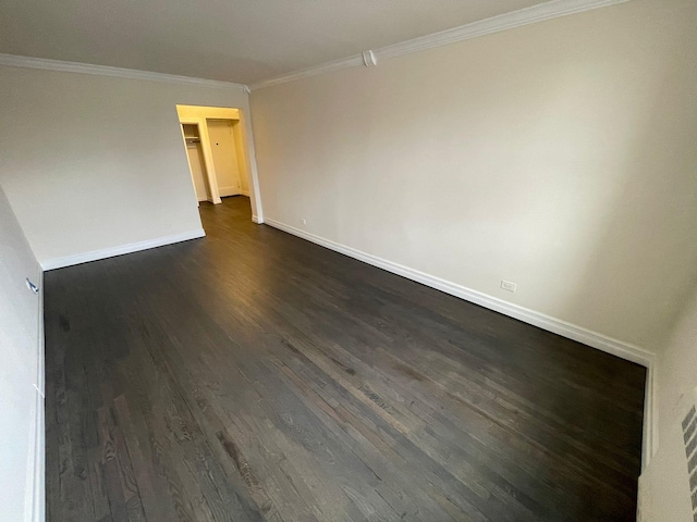 spare room featuring dark hardwood / wood-style flooring and crown molding