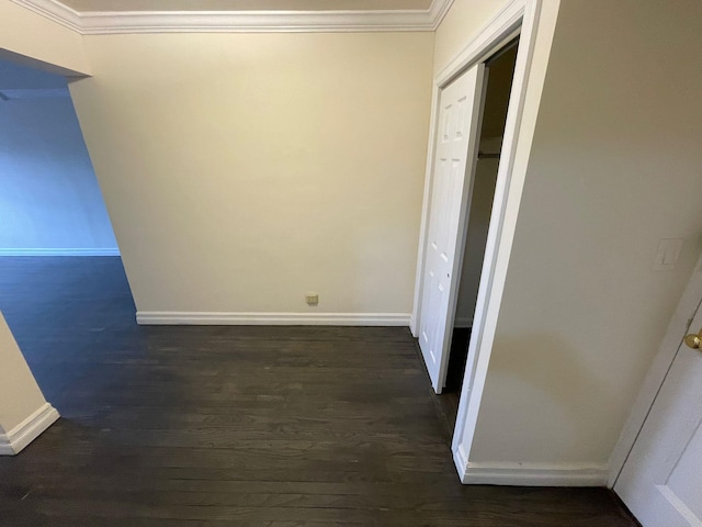 corridor with dark wood-type flooring and crown molding