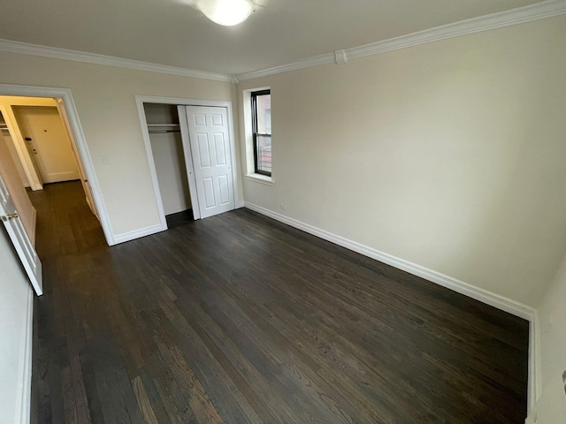 unfurnished bedroom featuring crown molding, a closet, and dark hardwood / wood-style flooring