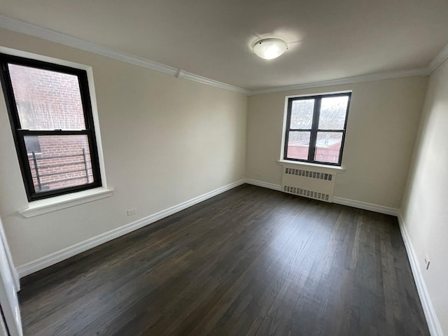 spare room featuring crown molding, radiator, and dark hardwood / wood-style flooring