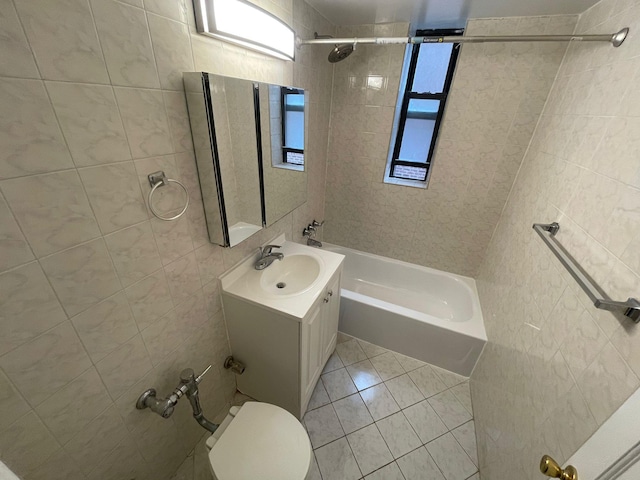 full bathroom with tile patterned floors, toilet, vanity, and tiled shower / bath combo