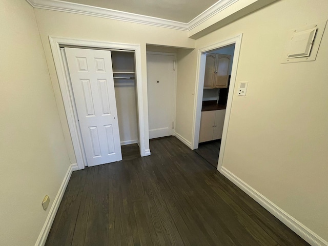 unfurnished bedroom featuring dark hardwood / wood-style flooring, a closet, and ornamental molding