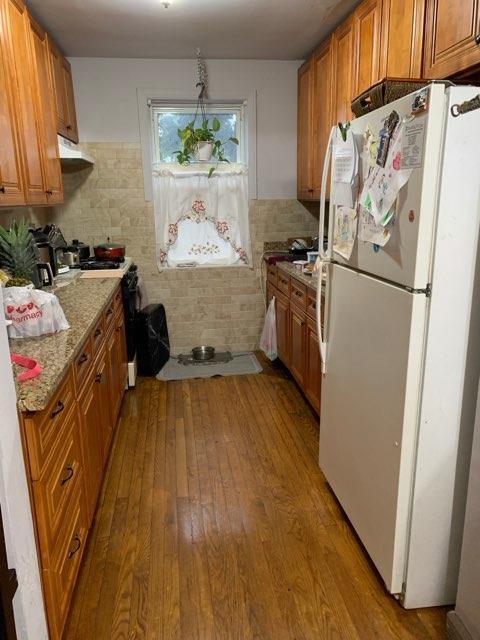 196-64 45th Ave, Flushing, NY 11358 - kitchen featuring freestanding refrigerator, hardwood / wood-style floors, brown cabinets, range with gas stovetop, and tasteful backsplash