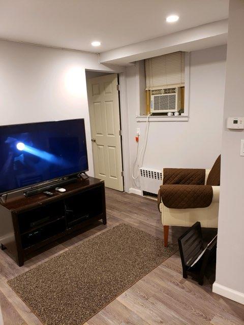 196-64 45th Ave, Flushing, NY 11358 - living room with cooling unit, wood finished floors, recessed lighting, and baseboards