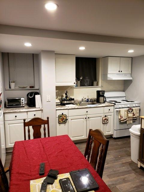 196-64 45th Ave, Flushing, NY 11358 - kitchen featuring white electric range, under cabinet range hood, dark wood-style flooring, light countertops, and recessed lighting