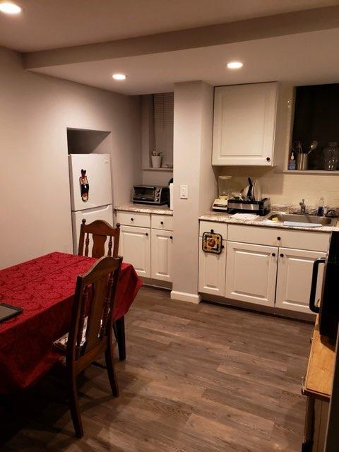 196-64 45th Ave, Flushing, NY 11358 - kitchen featuring freestanding refrigerator, a sink, recessed lighting, white cabinets, and dark wood-style floors