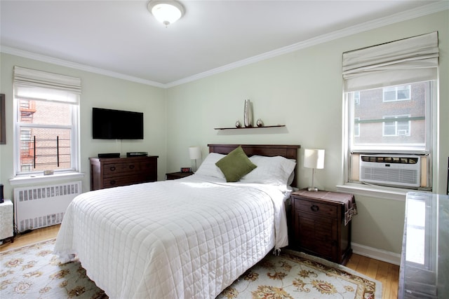 bedroom with radiator heating unit, light hardwood / wood-style flooring, cooling unit, and ornamental molding