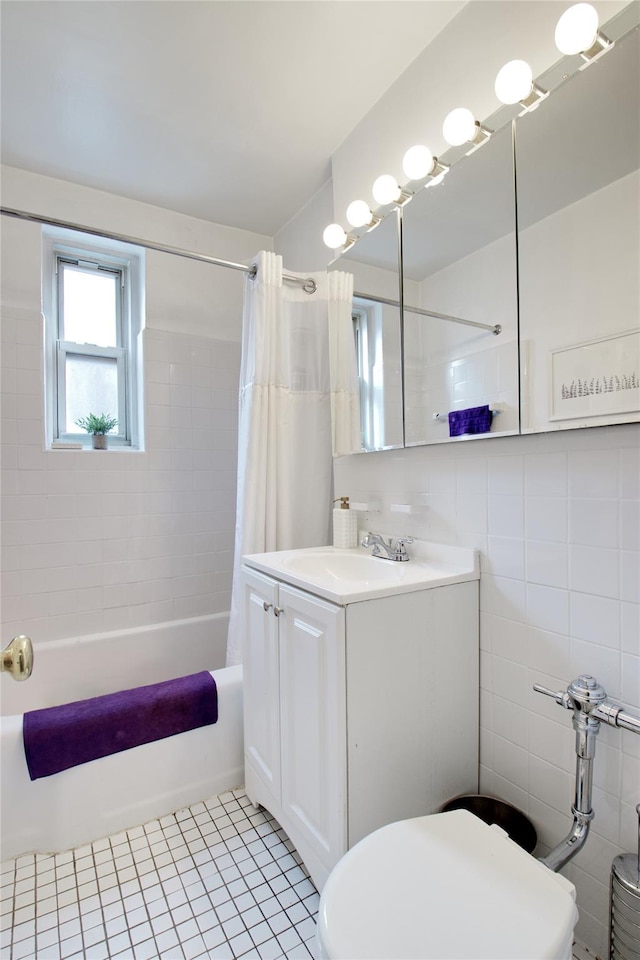 full bathroom with tile patterned flooring, vanity, shower / tub combo, tile walls, and toilet