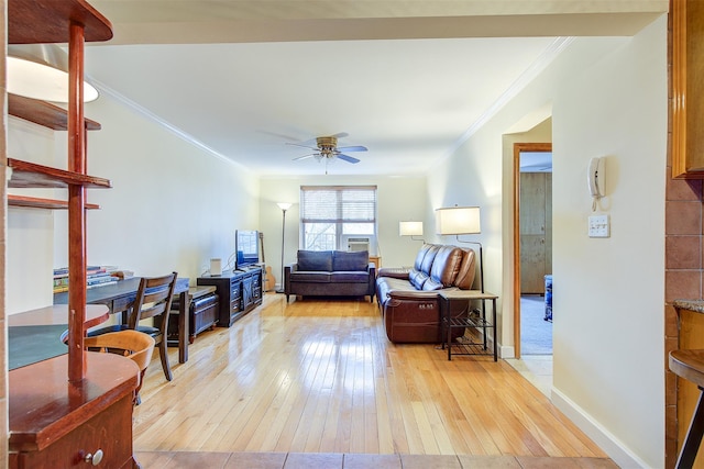 living room with light wood-type flooring, crown molding, baseboards, and a ceiling fan