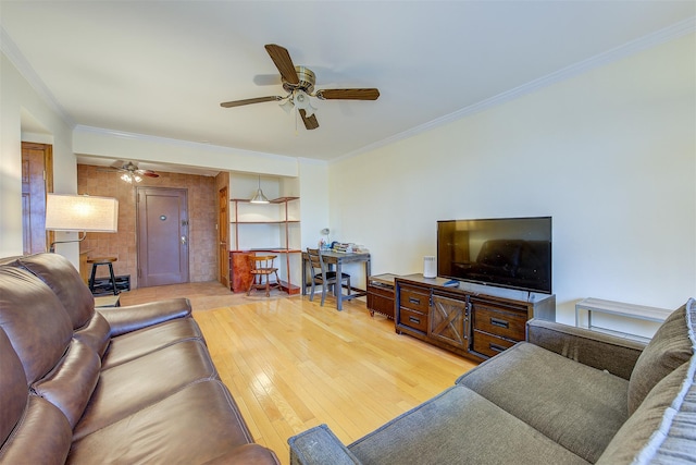 living area with light wood-style flooring, ornamental molding, and a ceiling fan