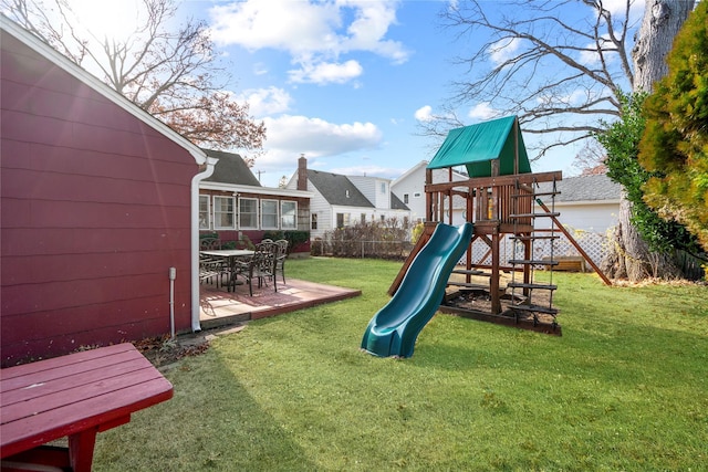 view of playground featuring a lawn and a patio