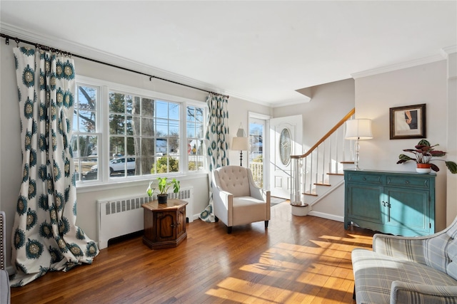 living area with crown molding, radiator heating unit, and hardwood / wood-style flooring