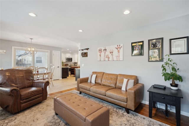 living room featuring a chandelier and light wood-type flooring