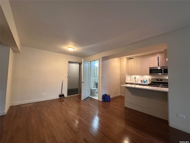 kitchen with backsplash, appliances with stainless steel finishes, dark hardwood / wood-style floors, and light brown cabinets