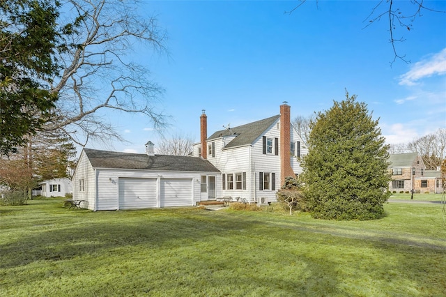 back of house featuring a garage and a lawn