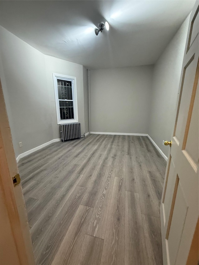 spare room featuring radiator and light wood-type flooring