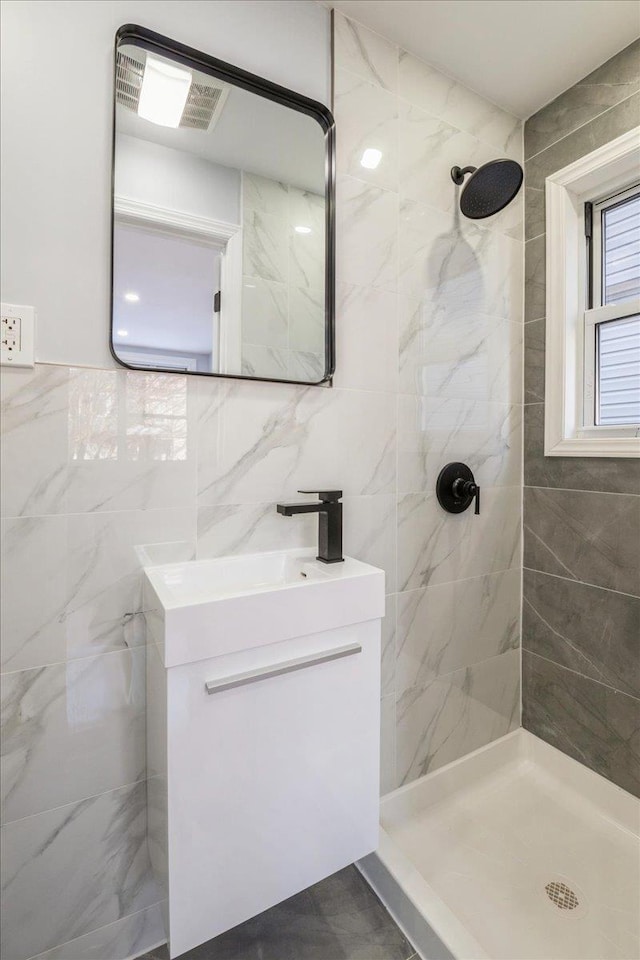 bathroom featuring tiled shower and tile walls