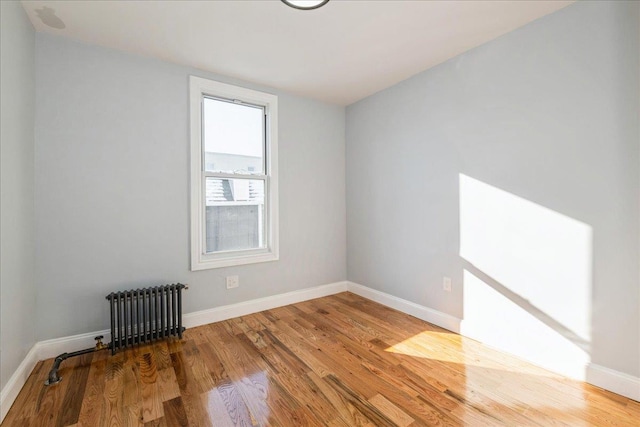 spare room with hardwood / wood-style flooring and radiator heating unit