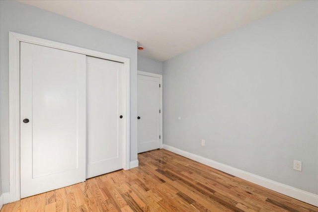 unfurnished bedroom featuring light hardwood / wood-style flooring and a closet