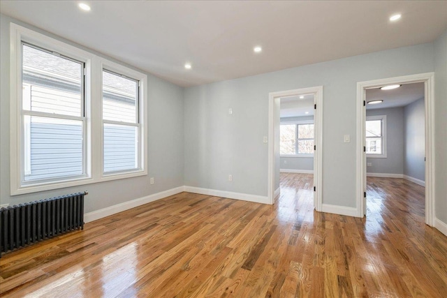 unfurnished room with light wood-type flooring and radiator