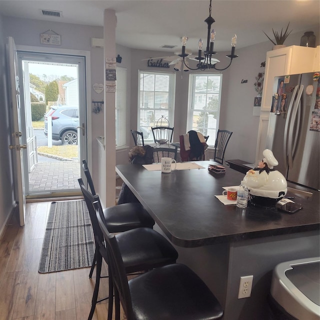 dining area featuring an inviting chandelier, light hardwood / wood-style floors, and plenty of natural light