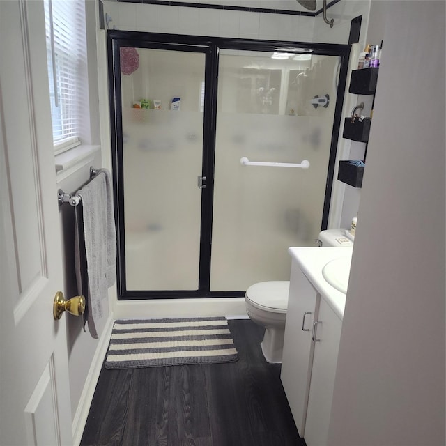 bathroom with a shower with shower door, wood-type flooring, toilet, and vanity