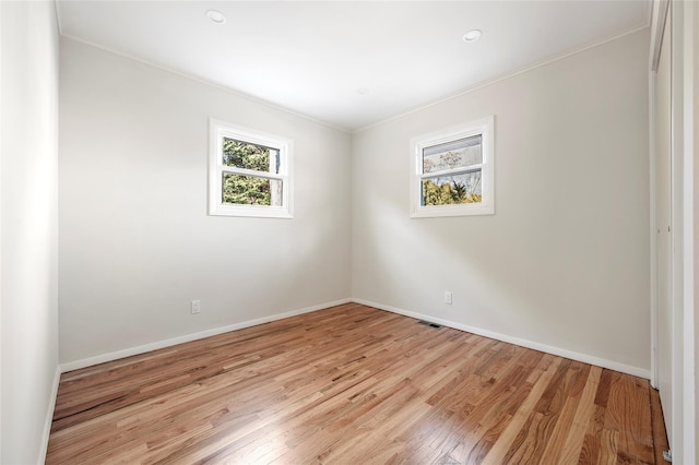 empty room with light hardwood / wood-style floors and ornamental molding