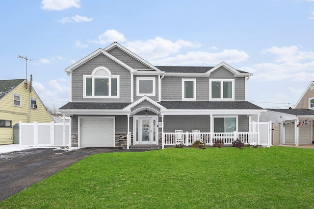 view of front of property with a garage, covered porch, and a front yard