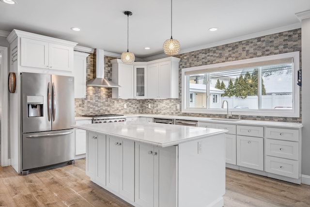 kitchen featuring sink, white cabinetry, stainless steel appliances, and wall chimney exhaust hood