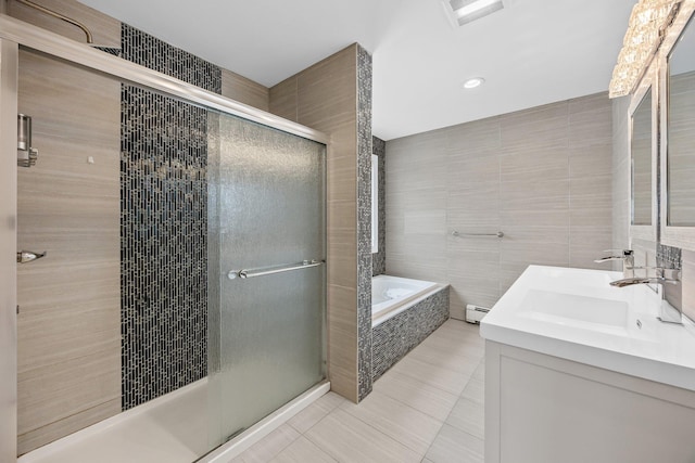 bathroom with a baseboard radiator, tile patterned flooring, shower with separate bathtub, sink, and tile walls