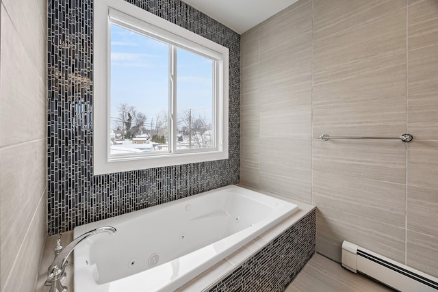 bathroom with tile walls, a baseboard heating unit, tiled tub, and tile patterned flooring