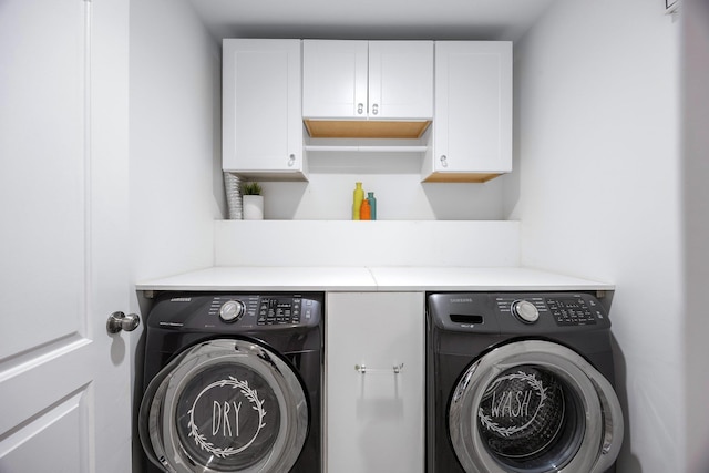 laundry area featuring washer and dryer and cabinets