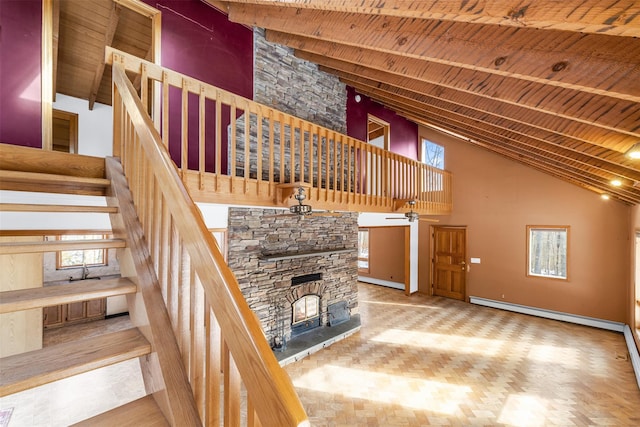 unfurnished living room featuring wooden ceiling, a baseboard heating unit, high vaulted ceiling, and a stone fireplace